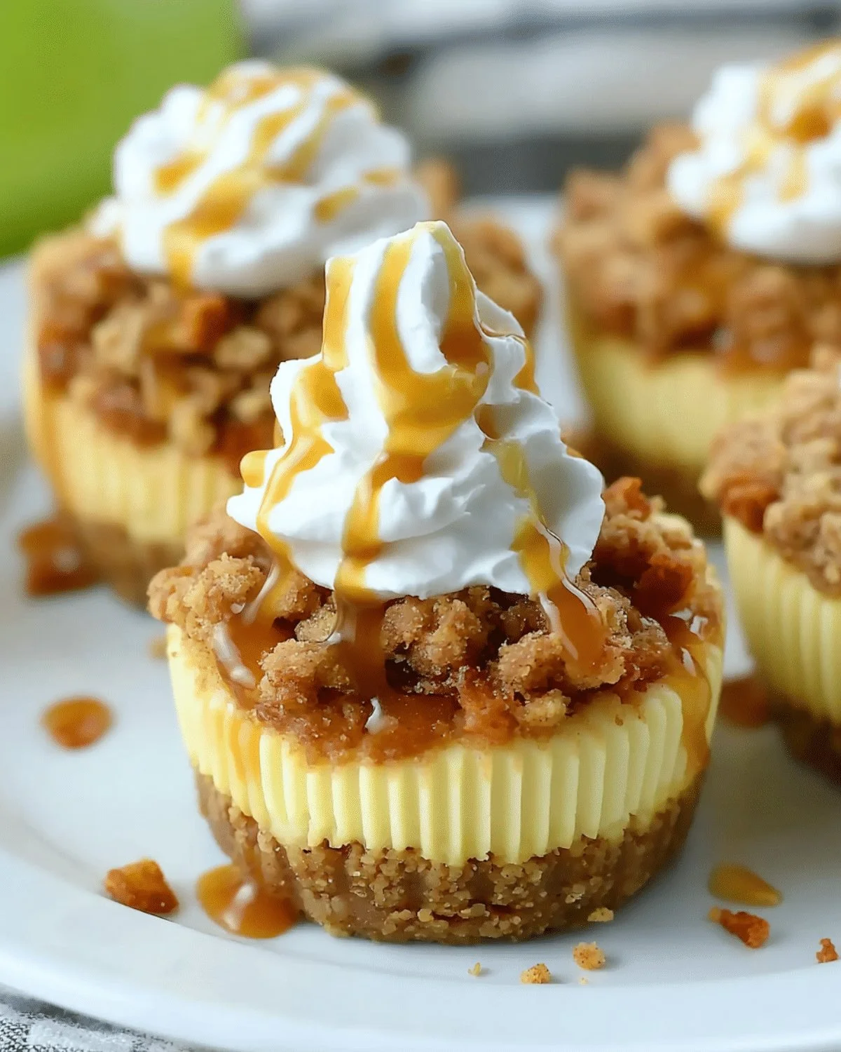 Delicious apple crisp mini cheesecakes topped with cinnamon and crumbs