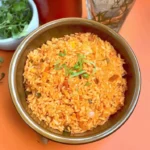 Bowl of authentic Mexican red rice garnished with herbs and spices