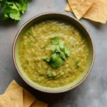 Delicious homemade green sauce in a bowl with fresh herbs and ingredients