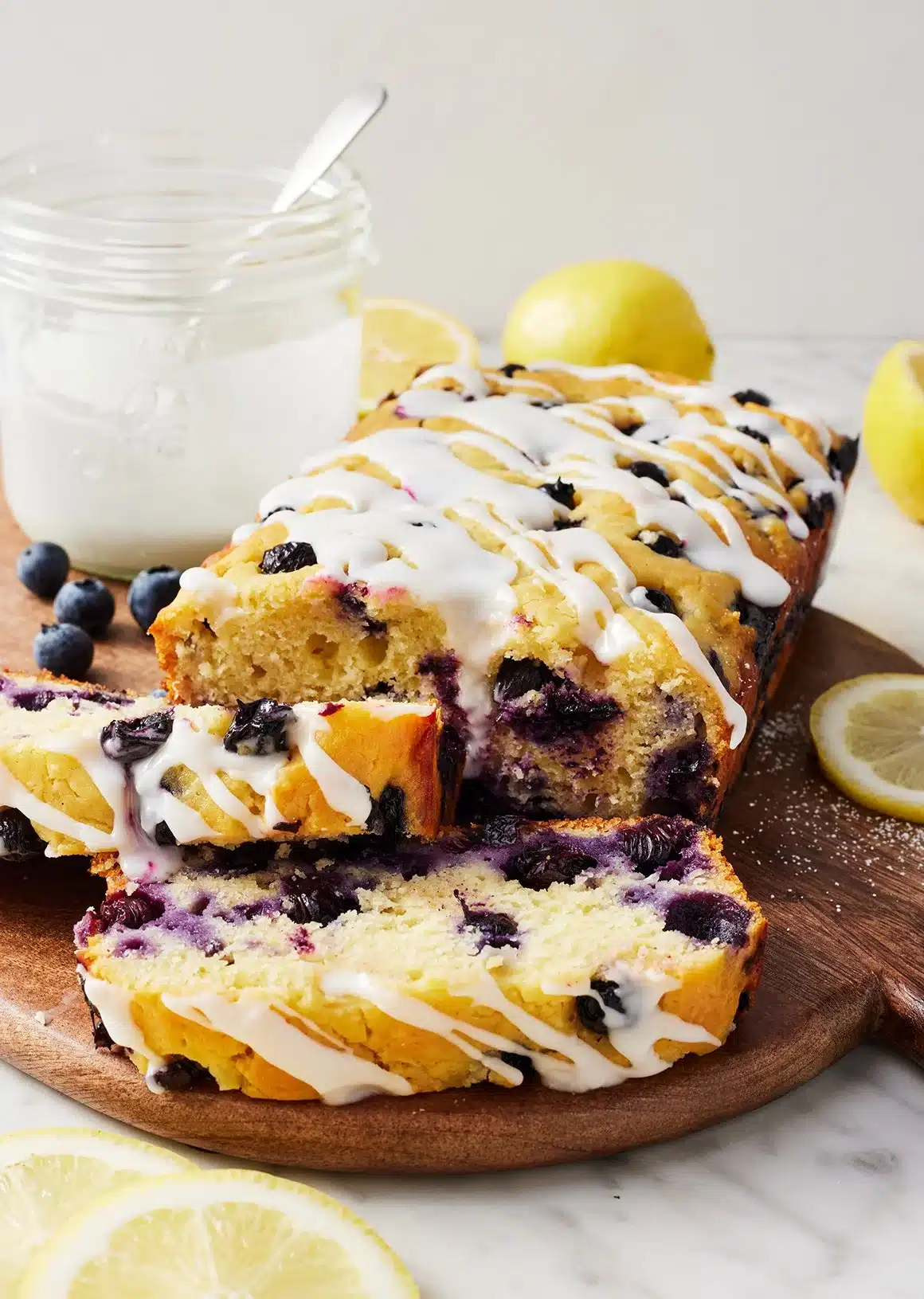 Loaf of homemade lemon blueberry bread with blueberries on a wooden table