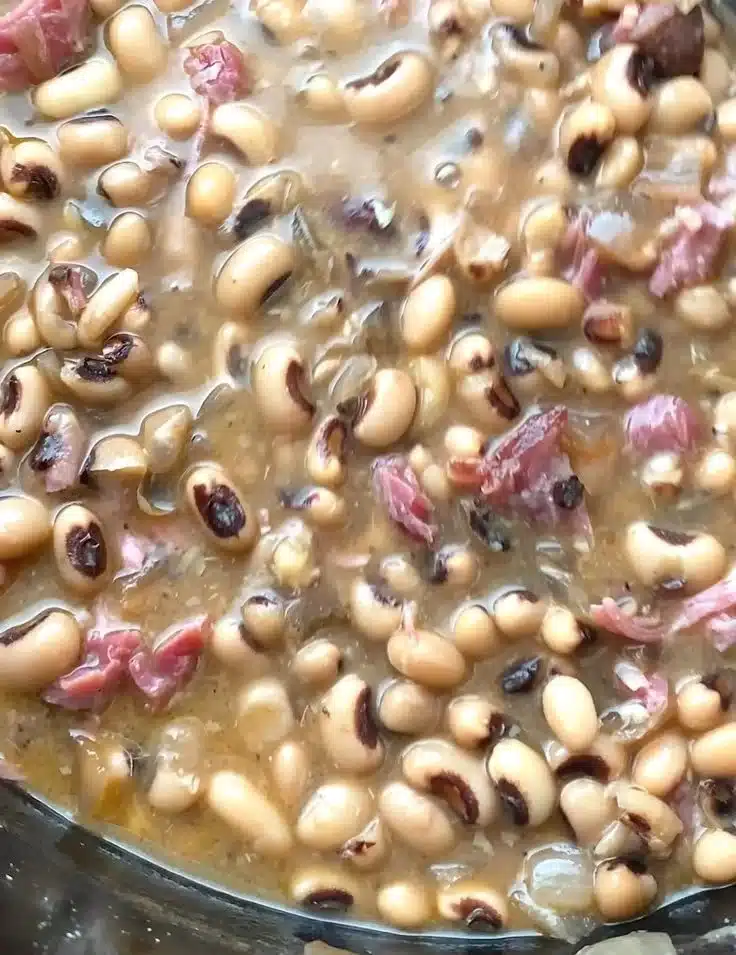 A bowl of slow cooker black-eyed peas garnished with herbs, ready to serve.