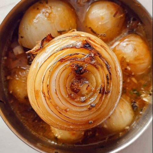 A bowl of steaming delicious onion boil garnished with herbs.