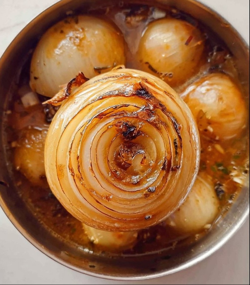 A bowl of steaming delicious onion boil garnished with herbs.