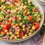 Colorful chickpea salad with fresh vegetables and herbs