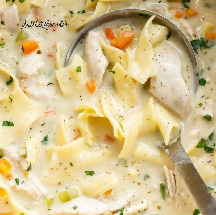 Bowl of creamy chicken soup garnished with herbs