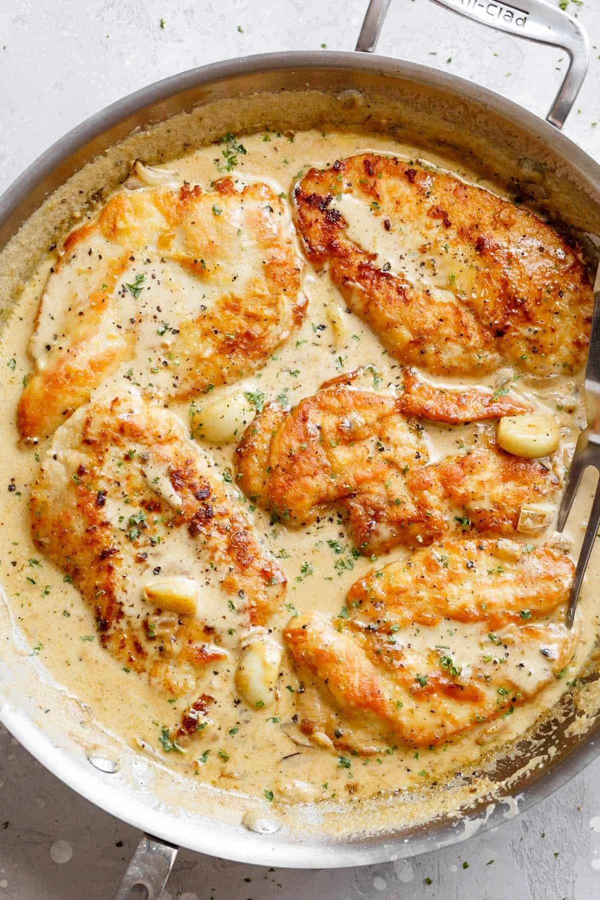Creamy garlic chicken breast served on a plate with herbs and spices