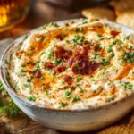 Delicious high protein crack dip served in a bowl with fresh vegetables.