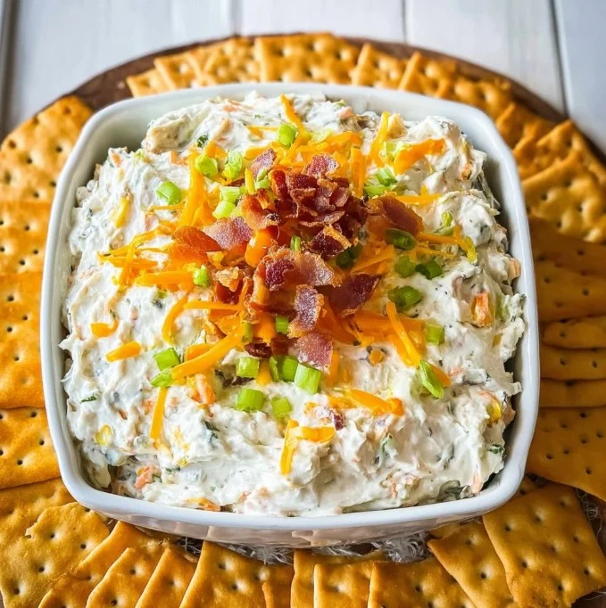 Delicious Million Dollar Crack Dip served in a bowl with crackers and fresh veggies