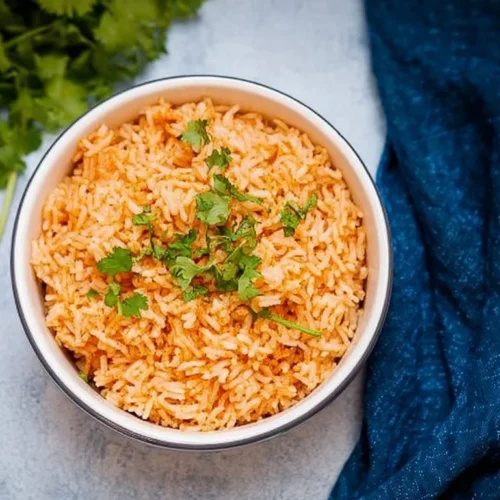Bowl of flavorful rice cooker Mexican rice with fresh ingredients