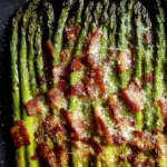 Delicious roasted parmesan asparagus topped with crispy bacon.