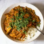 Delicious Chicken Lentil Curry served in a bowl with fresh herbs