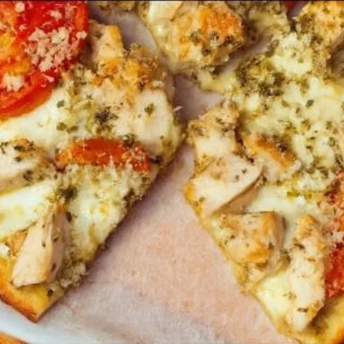 Delicious Chicken Pesto Flatbread topped with fresh basil and grilled chicken