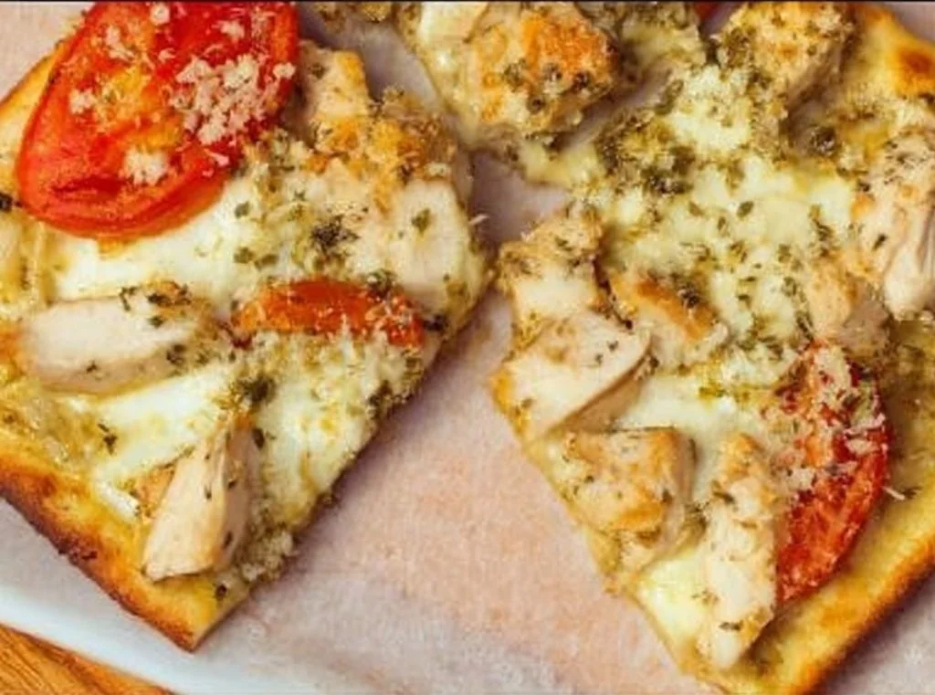 Delicious Chicken Pesto Flatbread topped with fresh basil and grilled chicken