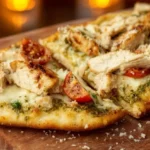Delicious Chicken Pesto Flatbread topped with fresh basil and grilled chicken
