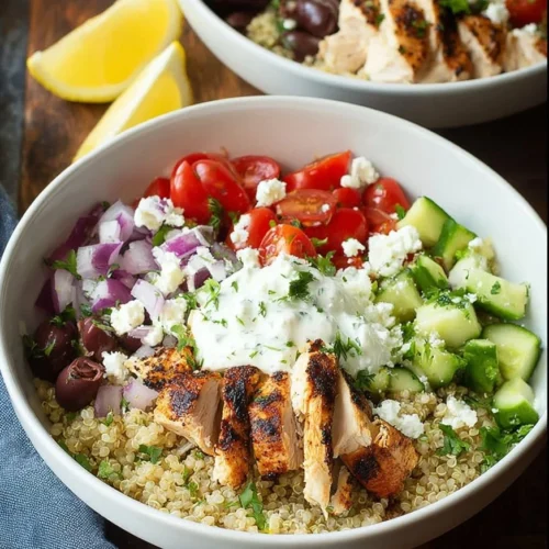 Grilled Greek chicken quinoa bowl with fresh vegetables and feta cheese