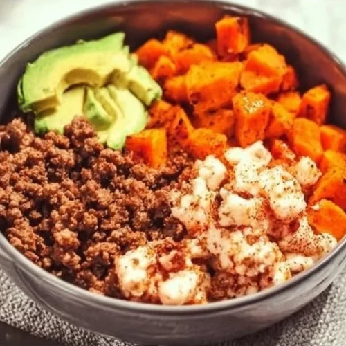 Ground Beef and Sweet Potato Bowl garnished with herbs in a white dish