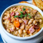 Bowl of homemade Ham and Bean Soup garnished with parsley