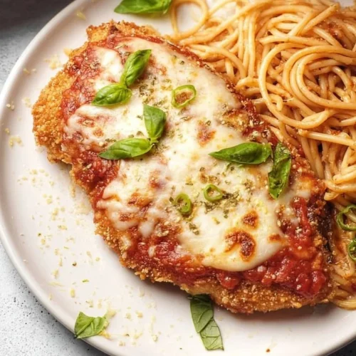 Plate of Healthy Baked Chicken Parmesan garnished with herbs