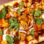 Loaded BBQ chicken flatbread pizza topped with fresh ingredients and BBQ sauce
