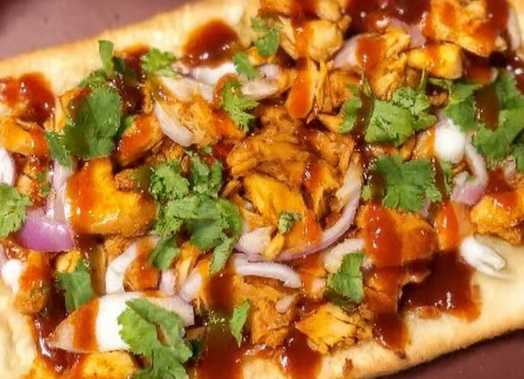 Loaded BBQ chicken flatbread pizza topped with fresh ingredients and BBQ sauce