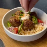 Mediterranean meatball bowl with fresh ingredients and vibrant colors
