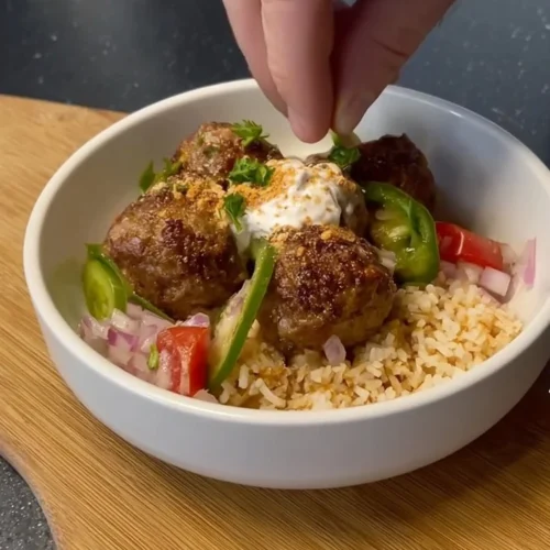 Mediterranean meatball bowl with fresh ingredients and vibrant colors