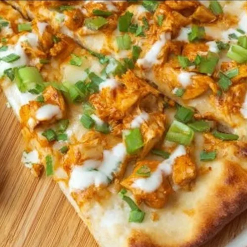 Saucy Buffalo Chicken Flatbread topped with cheese and fresh herbs