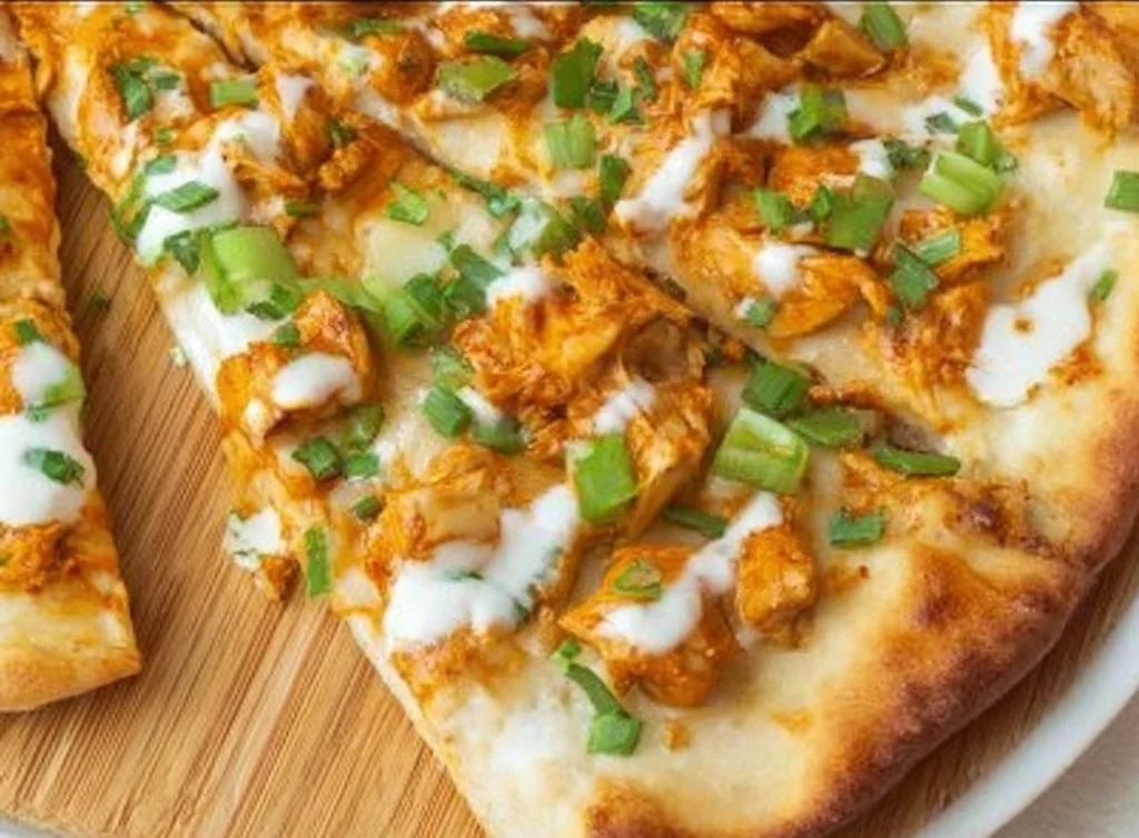Saucy Buffalo Chicken Flatbread topped with cheese and fresh herbs